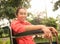 Portrait of happy positive disabled woman sitting in wheelchair and smile to camera in the outdoor public park