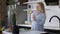 Portrait of happy pregnant Caucasian woman smelling milk smiling standing in kitchen at home. Joyful beautiful expectant