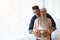 Portrait of happy pregnant religious muslim couple posing near window at home