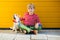 Portrait of happy preteen boy playing holding on hands with his dog Jack Russell Terrier on yellow background outdoor. Friendship