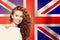 Portrait of happy pretty girl with white banner on the UK flag background. Young woman learning english language and traveling