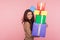 Portrait of happy pretty young woman smiling pleased to camera and holding mount of gift boxes, enjoying many best presents