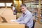 Portrait of happy professor sitting at desk using his laptop