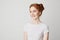 Portrait of happy redhead pretty girl with freckles smiling over white background.