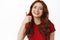 Portrait of happy redhead woman smiling pleased, showing thumbs up in approval, like and praise something great, nod to