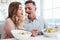 Portrait of happy romantic couple having dinner and eating salat together, while having lunch break in restaurant