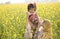Portrait of happy rural family in rapeseed agricultural field