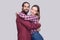 Portrait of happy satisfied bearded man and woman in casual style standing and hugging each other and looking at camera with toot