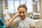 Portrait of happy schoolgirl with the sceptical look in the dental office