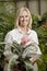 Portrait of a happy senior blond woman in botanical garden