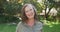 Portrait of happy senior caucasian woman standing in garden smiling