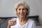 Portrait happy senior elderly woman holding glass of water.