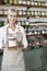 Portrait of a happy senior female employee holding spice jar in store