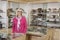 Portrait of a happy senior female optician standing in store