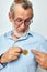 Portrait of happy senior man finance gold coins bitcoin posing unaltered