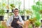 Portrait of happy senior man gardening wearing glasses and denim apron. Showing thumbs up