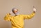 Portrait of happy senior millionaire man using smartphone cellphone make selfie in yellow sunglasses