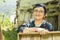 Portrait of a happy senior Muslim woman with eyeglass carrying a wooden box in outdoor area