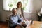 Portrait of happy senior spouses managing family business using laptop