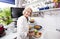 Portrait of happy senior woman chopping fresh vegetables at kitchen counter