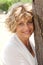 Portrait of a happy senior woman holding tree