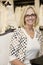 Portrait of a happy senior woman wearing eyeglasses sitting in bridal boutique