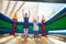 Portrait of happy siblings with arms raised jumping on bouncy castle