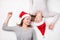 Portrait of happy sisters lying on the floor wearing Christmas hats