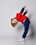 Portrait of happy smiling active frolic blond kid boy in blue and red hoodie and pants playing