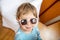 Portrait of happy smiling adorable toddler in baby sunglasses. cheerful child playing