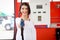 Portrait of happy smiling customer woman holding fuel petrol pump nozzle against for filling up her car, beautiful young lady