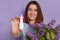 Portrait of happy smiling delighted woman showing nasal spray from allergic rhinitis, posing isolated over purple background,