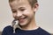 Portrait of happy smiling funny cute handsome child boy with white pet mouse hamster on shoulder on light copy space background.