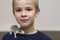 Portrait of happy smiling funny cute handsome child boy with white pet mouse hamster on shoulder on light copy space background.