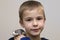 Portrait of happy smiling funny cute handsome child boy with white pet mouse hamster on shoulder on light copy space background.