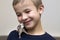 Portrait of happy smiling funny cute handsome child boy with white pet mouse hamster on shoulder on light copy space background.