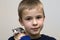 Portrait of happy smiling funny cute handsome child boy with white pet mouse hamster on shoulder on light copy space background.