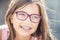 Portrait of happy smiling girl with dental braces and glasses