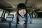 Portrait happy, smiling kid sitting in the car looking out windows, ready for vacation trip