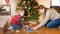 Portrait of happy smiling little boy with mother building railroad and playing with toy train on floor under Beautiful