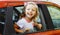 Portrait of happy smiling little child passenger sitting in red car