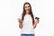 Portrait of happy smiling pretty woman in glasses holding credit card, mobile phone, laughing at camera easily paying