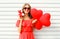 Portrait happy smiling woman holding in hands gift box and red air balloons heart shape over white