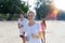 Portrait Of Happy Smiling Woman Running On Beach With Group Of Young Sport Runners Jogging Fitness Together