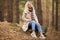 Portrait of a happy smiling woman sitting in the forest a spring day outside. Portrait of a beautiful blonde woman outdoor in a