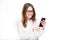 Portrait happy, smiling woman texting on her smart phone, isolated white background. Communication concept. Internet, phone addict