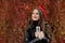 Portrait of happy student girl in red cap holding silver metal thermos in hands during autumn outside