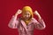 Portrait of happy success confident young teenage Asian muslim girl shows winning gesture celebrating victory, wearing yellow