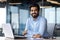 Portrait of happy and successful businessman, indian man smiling and looking at camera, satisfied with achievement