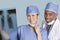 Portrait of happy surgeons holding x-ray report over light blue background